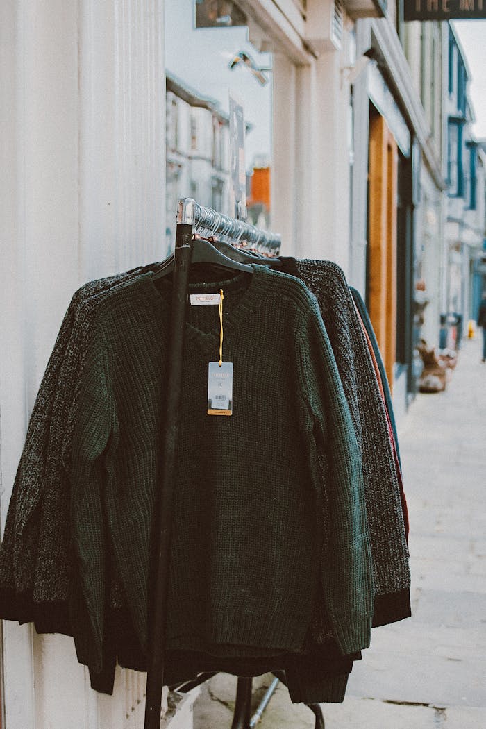 services-01 Sweaters displayed on a clothing rack outside a shop, perfect for street shopping environments.