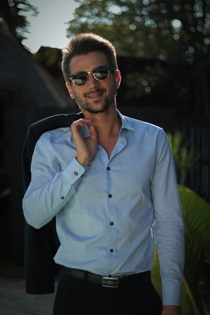 services-04 Confident young man in sunglasses poses outdoors in casual attire, exuding style and charisma.